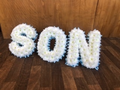 SON - SON Letters arranged with a pale blue ribbon edge with white based flowers. This can be made in your own choice of flowers and can also have added flower sprays onto the letters if you wish. SON - SON Letters arranged with a pale blue ribbon edge with white based flowers. This can be made in your own choice of flowers and can also have added flower sprays onto the letters if you wish.
