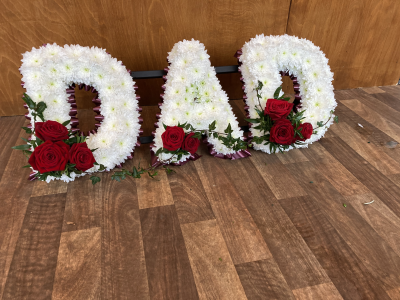 Red Dad Tribute - DAD- Red Ribbon edge, White based flowers, finished with Red Rose letter sprays Red Dad Tribute - DAD- Red Ribbon edge, White based flowers, finished with Red Rose letter sprays